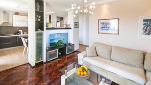 A modern living room with a sofa, a glass coffee table, and a TV on a stand. - Villa Marino in Makarska, private pool (Makarska)