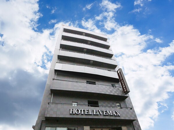 Ein mehrgeschossiges Hotelgebäude mit einem Schild mit der Aufschrift "HOTELLIVEMAX" an der Fassade.