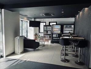 A modern hotel lobby with a bar area, seating, and a refrigerator. - HOTEL LiVEMAX Ueno-Ekimae (Tokyo)