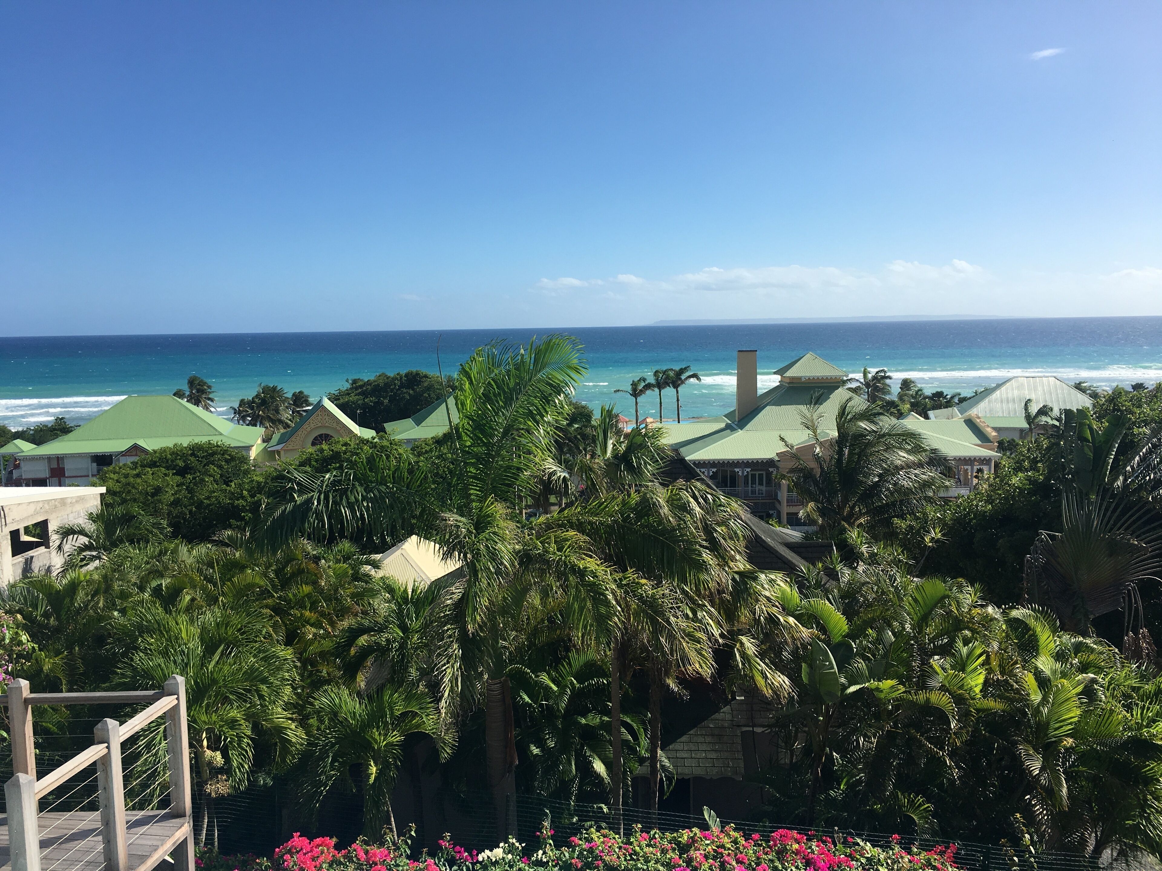 Ein Resort mit mehreren Gebäuden, Palmen und Blick auf den Ozean.