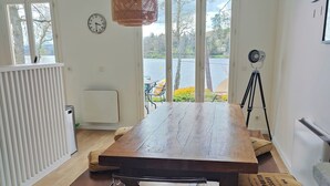 A dining area with a wooden table, benches, and a hanging light fixture.