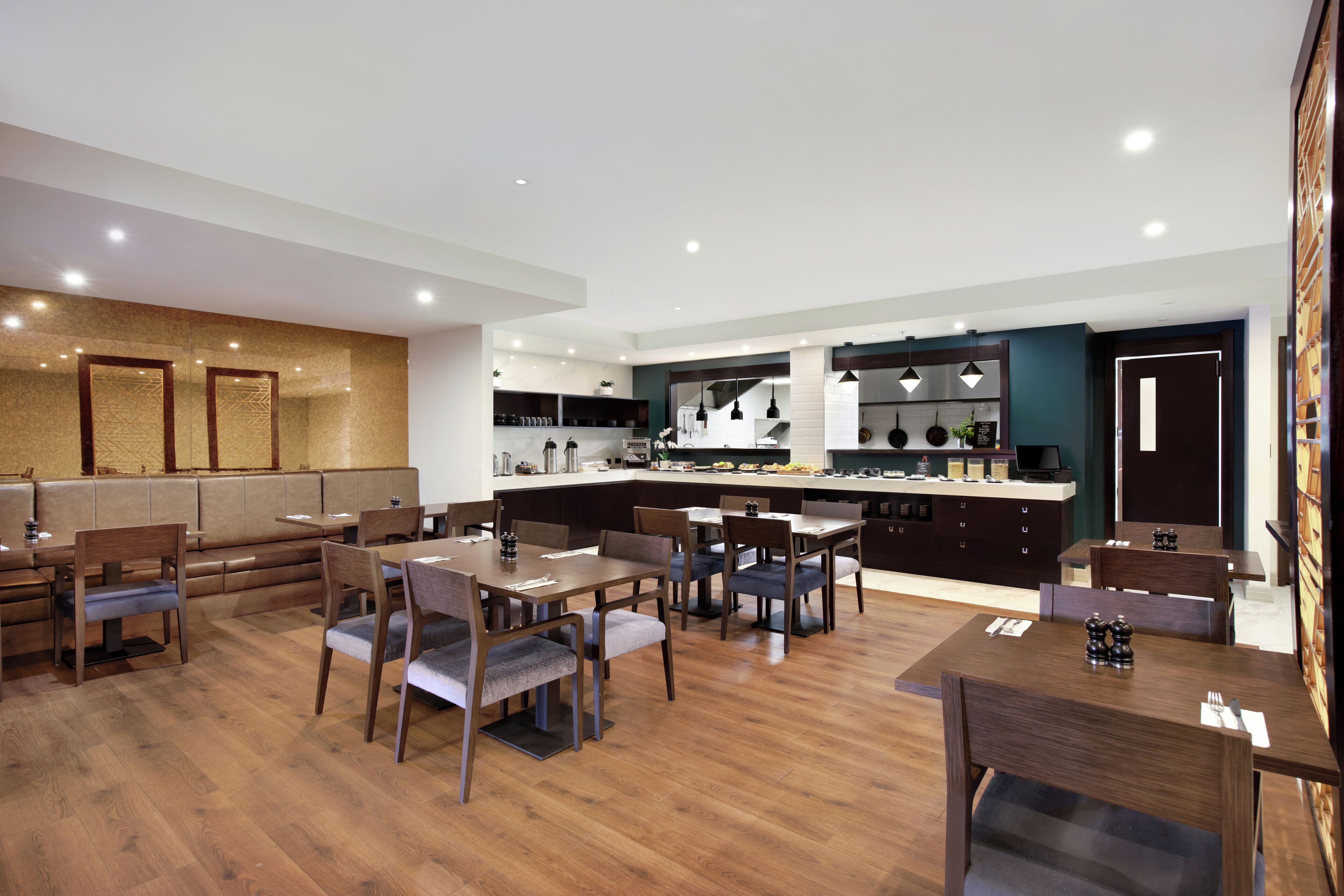 A modern dining area with wooden furniture and a kitchen in the background.