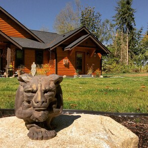 A rustic cabin with a stone lion sculpture in the foreground. - Spectacular View! Romantic! Special 50% off per month, 25% off per week! (Hansville)