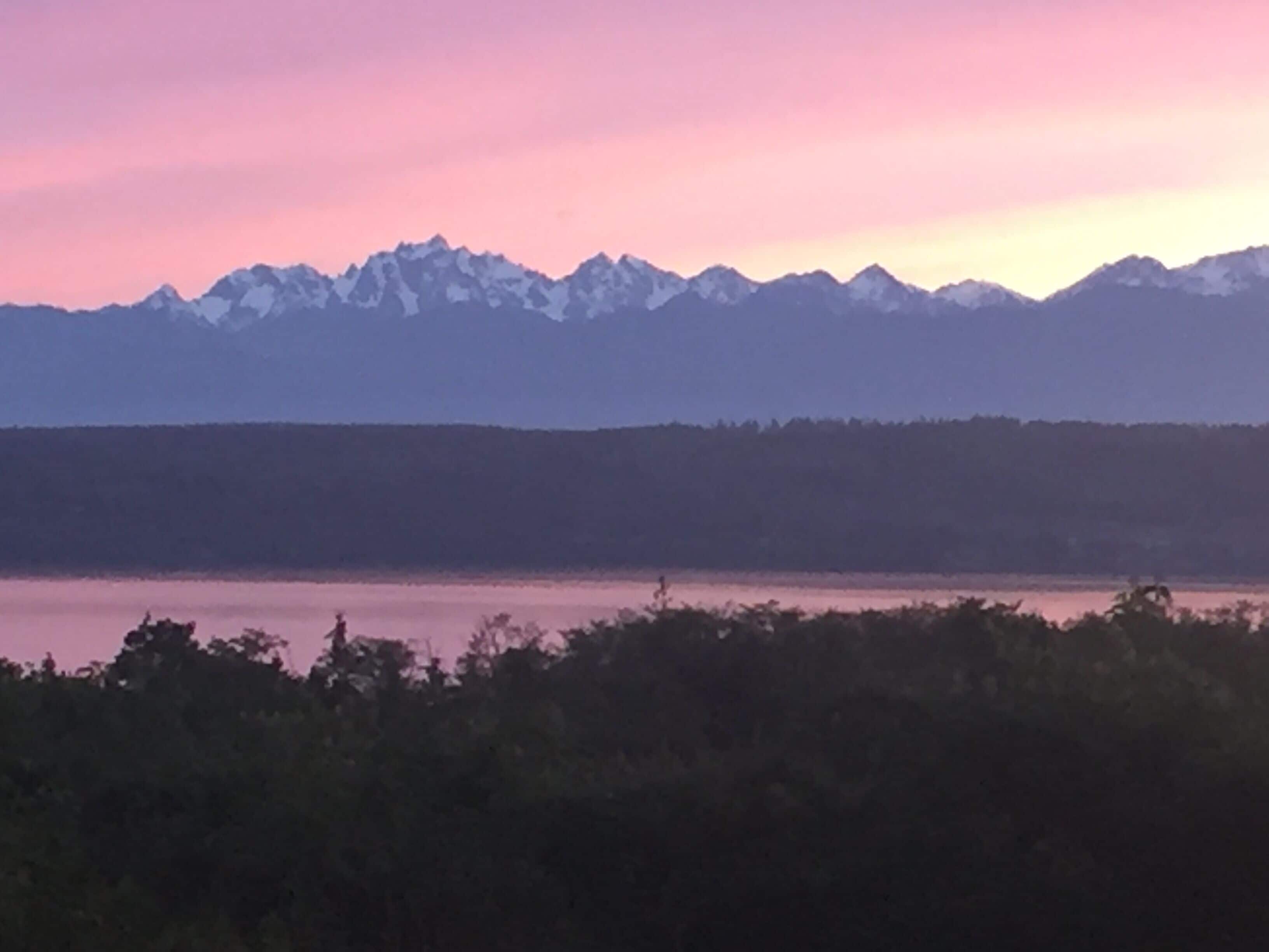 A mountain range with a lake in the foreground.