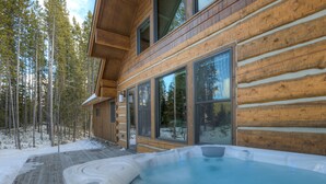 Eine Holzhütte mit Whirlpool und Terrasse.