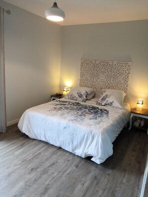 Cozy retreat with a large bed, bedside tables, and a decorative panel above.