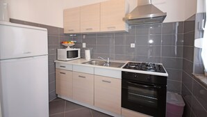 A modern kitchen with a refrigerator, microwave, sink, stove, and oven.