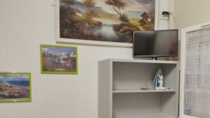 A room with a TV on a stand, a white cabinet with storage bins, and two framed pictures on the wall. -  * RUNNING AND WALKING BEACH * enclosed garden * CLIM * WIFFI * PARKING * (Saint-Cyprien)