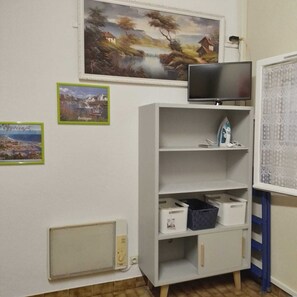 A room with a TV on a stand, a white cabinet with storage bins, and two framed pictures on the wall. -  * RUNNING AND WALKING BEACH * enclosed garden * CLIM * WIFFI * PARKING * (Saint-Cyprien)