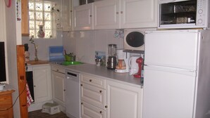 A kitchen with white cabinets, a microwave, a coffee maker, and a blender. -  * RUNNING AND WALKING BEACH * enclosed garden * CLIM * WIFFI * PARKING * (Saint-Cyprien)