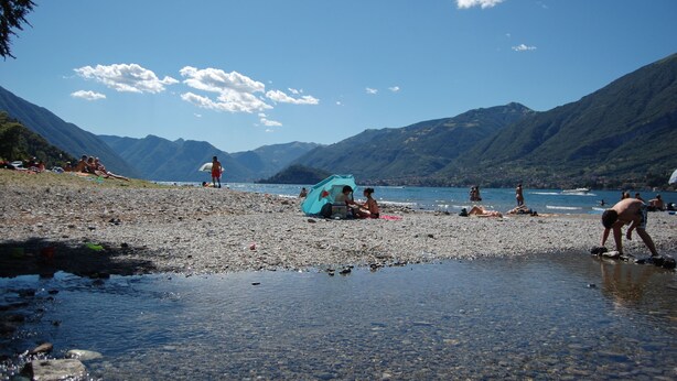 A beach with people, a tent, and mountains in the background. - The Best Place To Visit Como Lake (Barni (COMO))