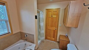 Une salle de bain avec une baignoire, des toilettes et une douche.
