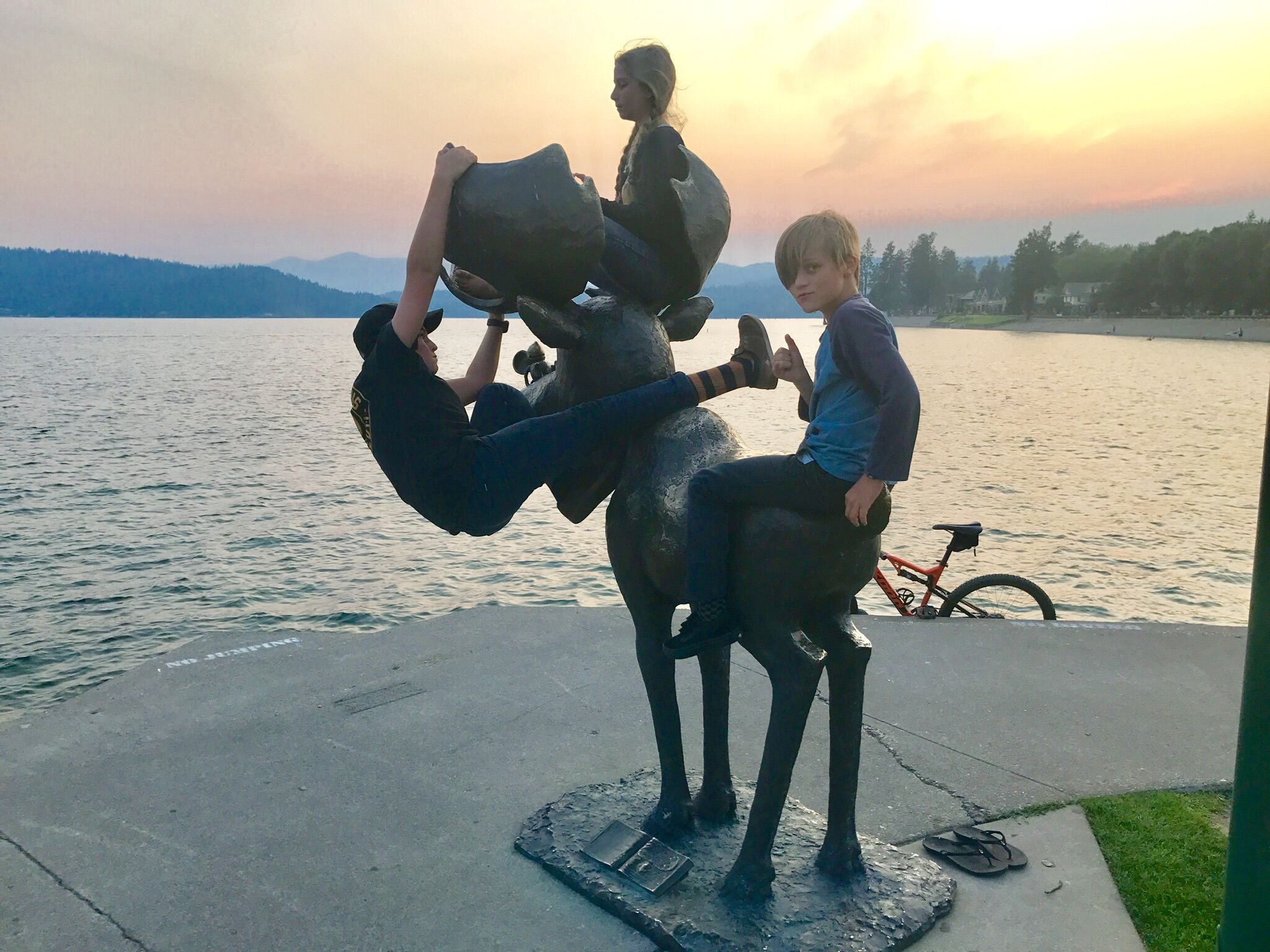 A sculpture of a person riding an elephant, with a bicycle in the background.