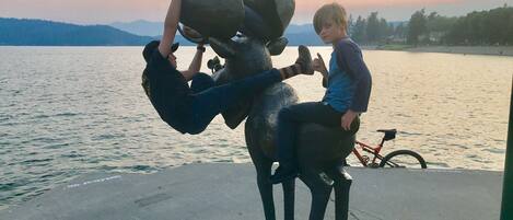 A sculpture of a person riding an elephant, with a bicycle in the background.