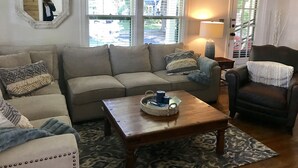 A living room with a beige sofa, a wooden coffee table, and a patterned rug. - Best Place / Best Condition / Best Price !!! Go to everything !!! (coeur d alene)