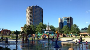A public park with water play areas, a playground, and a large building in the background. - Best Place / Best Condition / Best Price !!! Go to everything !!! (coeur d alene)