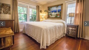 A bedroom with a large bed, a nightstand, a lamp, a painting, and a window with curtains. - Best Place / Best Condition / Best Price !!! Go to everything !!! (coeur d alene)
