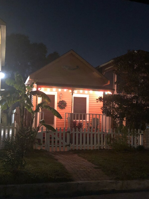 A house with a porch, a white picket fence, and a pathway leading to the entrance. - Walk to restaurants/bars. We are 3 blocks from beach. Beach chairs provided. (Galveston)