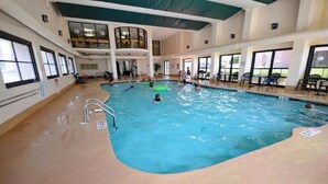 An indoor swimming pool with multiple lanes, a seating area with chairs, and a high ceiling with skylights. - Amazing Views - Ocean Front 3BR Condo! (Myrtle Beach)
