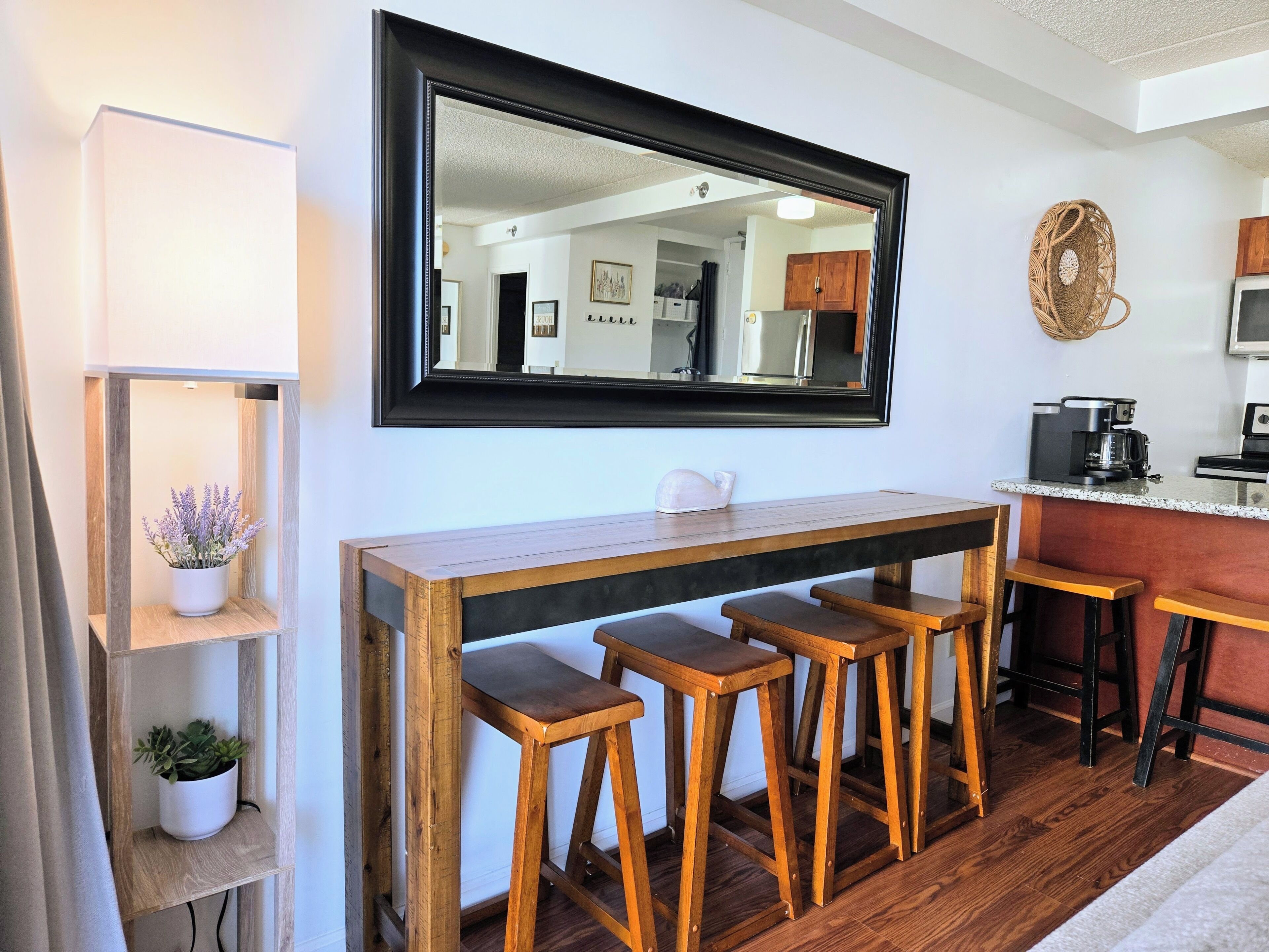 Eine Küche mit einer Holztresen-Bar, einem großen Spiegel und einem Blumentopf.
