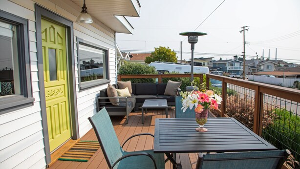 Una terraza con mobiliario exterior, una mesa y una planta en maceta.