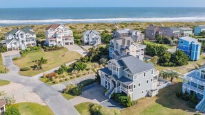 A coastal residential area with houses featuring large windows and balconies, a clear view of the ocean, and well-maintained lawns. - Oceanview Dog Friendly Home with Pool, Hot Tub, Elevator, Game and Media Rooms (Avon)