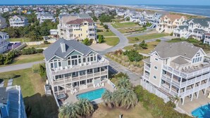 A residential area with multiple two-story houses, a swimming pool, and a view of the ocean. - Oceanview Dog Friendly Home with Pool, Hot Tub, Elevator, Game and Media Rooms (Avon)