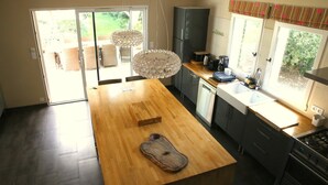 Una cocina moderna con una isla de madera, un refrigerador y un lavabo.