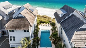 Zona residencial con piscina, vista al mar y casas con tejados inclinados.