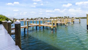 A wooden pier extending into calm water, supported by wooden posts, with a clear sky above.