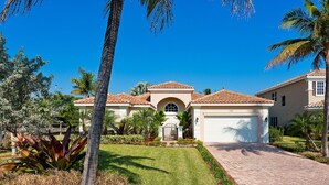 A residential house with a tiled roof, a garage, and a well-maintained lawn.