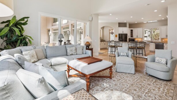 A spacious living room with a large sectional sofa, a coffee table, and a dining area with chairs. - Luxury 6BR 3rd Row Home w/ Patio & Private Pool (Hilton Head Island)