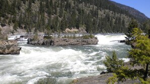 A river with a waterfall and a bridge. - A Cabin On The River<br>Three days minimum<br>Closed from October 15th to April 1 (Troy)