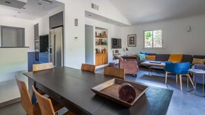 Una cocina moderna con comedor, sofá y televisor.