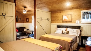 A cozy room with a bed, a desk, and a chair. There is a window with curtains and a painting on the wall. - SWEET HILL COUNTRY CABIN in the PERFECT location;  Sleeps 4-5 (Dripping Springs)