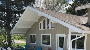 A small cabin with a porch, multiple windows, and outdoor seating. - Country Living in the City (Bozeman)