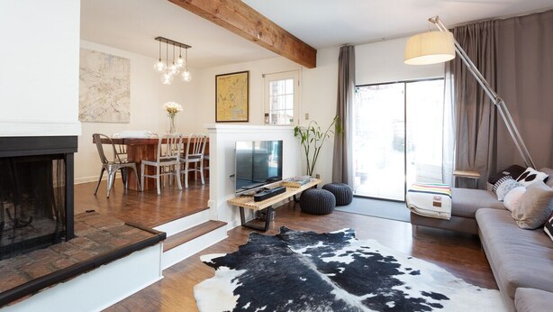 Una sala moderna con chimenea, comedor y sofá.