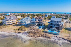 A coastal residential area with multiple two-story houses featuring balconies and a swimming pool.