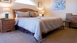 A bedroom with a large bed, two bedside tables, a chair, and a wall-mounted lamp. - Private Pool house with private pool, near all famous attractions!!! (Kissimmee)