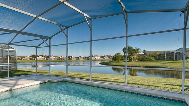 A pool area with a clear view of a lake and surrounding houses. - Private Pool house with private pool, near all famous attractions!!! (Kissimmee)