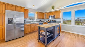 Una cucina moderna con mobili in legno, elettrodomestici in acciaio inossidabile e un'ampia isola.
