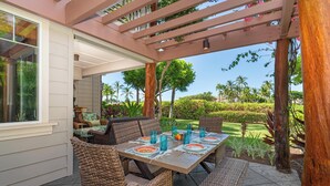 An outdoor patio with wicker furniture, a table set for dining, and a pergola overhead. - Hilton Waikoloa Pool Pass for stays in 2026/Waikoloa Golf Discounts (Waikoloa Beach Resort)