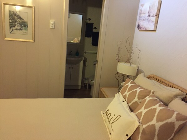 A bedroom with a bed, a nightstand, a lamp, and a wall-mounted mirror. - Beautiful Condo with excellent Birch Bay view!! (Blaine)
