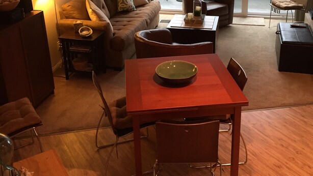 Een moderne woonkamer met een bank, een eettafel en uitzicht op een balkon.