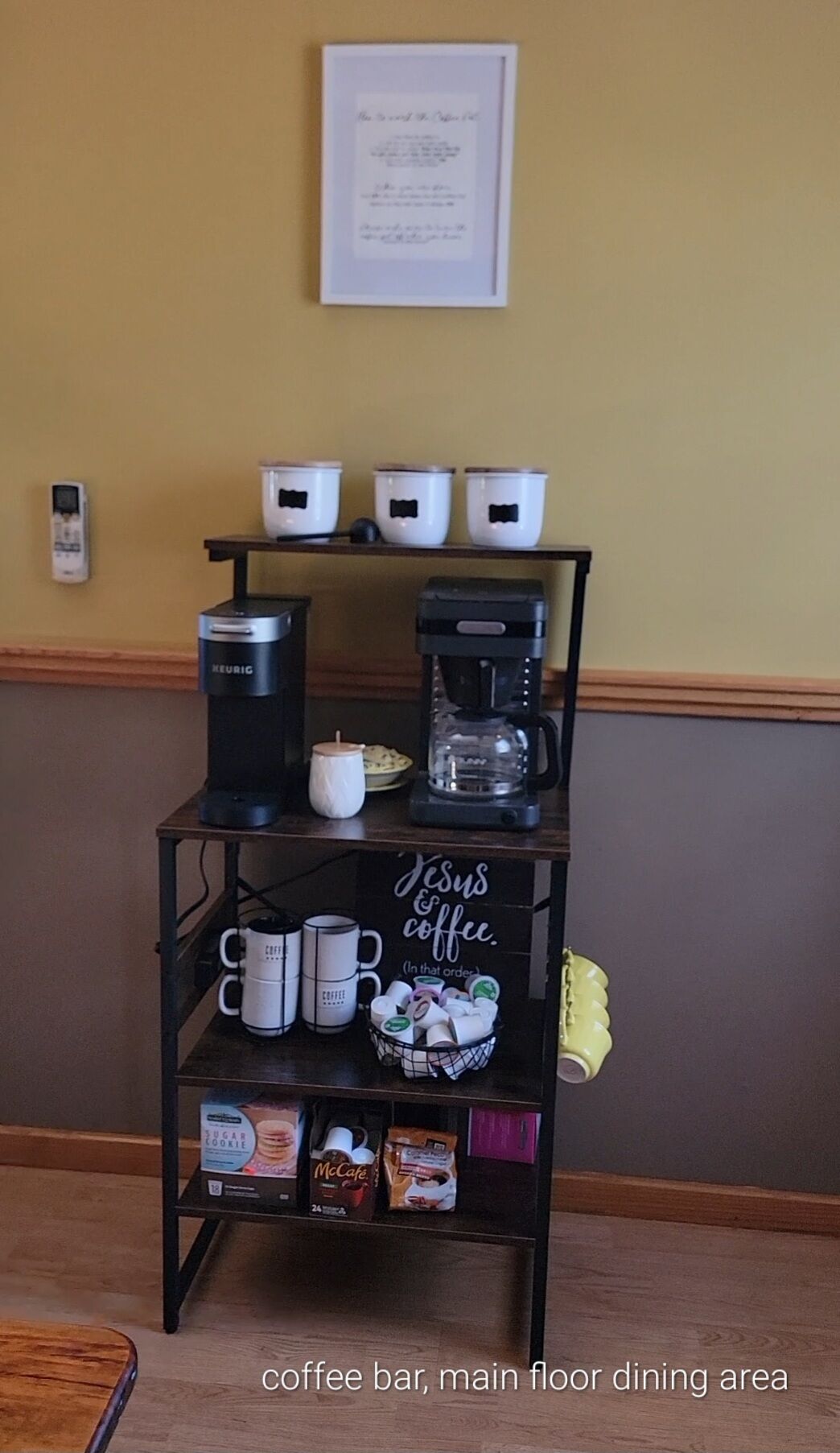A coffee bar with a coffee maker, a Keurig, and a mug on a shelf.
