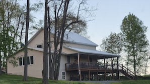 A large two-story house with a covered porch and a staircase leading to an upper level.