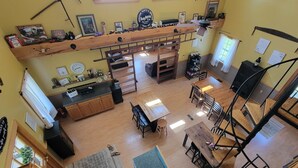 A spacious kitchen with a dining area, wooden furniture, and a loft bedroom with a bunk bed.