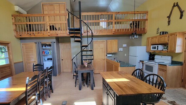 A spacious kitchen with wooden cabinets, a central island, and a built-in microwave.