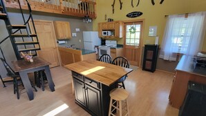 A compact kitchen with wooden cabinets, a central island, and a built-in stove.