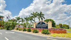 A marina sign with "Burnt Store Marina" and "BOATING, GOLFING, DINING" text, surrounded by palm trees and a small waterfall. - 3 Bedroom 2 Bath 2 Car Garage includes Golf Cart Usage (Punta Gorda)